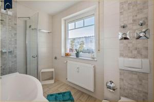 Un baño con ducha, inodoro y ventana. en Ferienwohnung Pretzer, en Ostseebad Koserow 15 fotos más