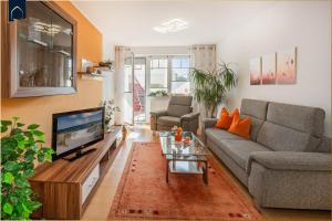 Una sala de estar con un sofá y un televisor. en Ferienwohnung Pretzer, en Ostseebad Koserow