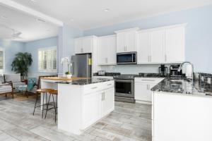 a kitchen with white cabinets and a counter top at Three Palms in Palm Coast +51 photos