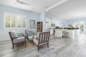 a living room with chairs and a kitchen at Three Palms in Palm Coast
