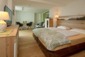 a bedroom with a large bed and a desk at Eldorado - Ferienwohnungen & Suiten in Bolsterlang +151 photos