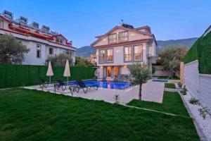 a house with a swimming pool in a yard at Yaz Villa 2 in Fethiye