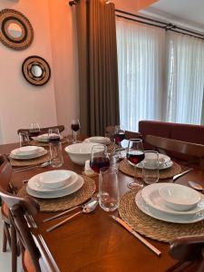 una mesa de madera con platos y copas de vino en Yaz Villa 2, en Fethiye