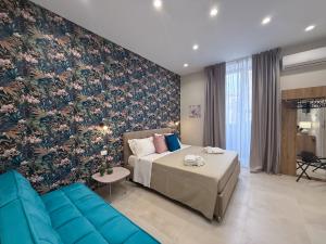 カターニアにあるTown House 54のベッドと青いソファのある寝室