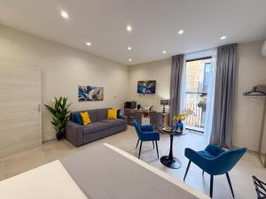 a living room with a couch and a table and chairs at Town House 54 in Catania