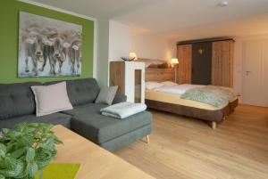 a living room with a couch and a bed at Eldorado - Ferienwohnungen & Suiten in Bolsterlang