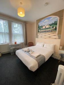 une chambre avec un grand lit avec un tableau au mur dans l'établissement United Lodge Hotel, à Londres