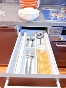 a kitchen sink with utensils in a cabinet at 西戸崎3丁目8番1号 in Fukuoka
