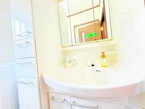 a bathroom with a white sink and a mirror at 西戸崎3丁目8番1号 in Fukuoka