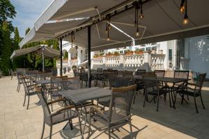 an outdoor restaurant with tables and chairs and umbrellas at Prémium Panzió Miskolctapolca in Miskolctapolca +56 photos