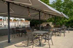 a patio with tables and chairs under a tent at Prémium Panzió Miskolctapolca in Miskolctapolca