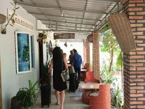 een groep mensen met bagage die een gebouw binnenlopen bij Phonluer Angkor Homestay, in Siem Reap