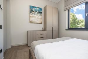 a bedroom with a white bed and a window at Baltijos parkas - Šventoji in Šventoji