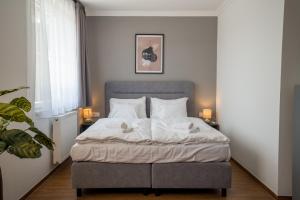 a bedroom with a bed with white sheets and pillows at Prémium Panzió Miskolctapolca in Miskolctapolca