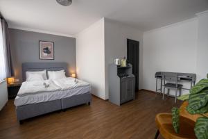 a bedroom with a bed and a table and a desk at Prémium Panzió Miskolctapolca in Miskolctapolca