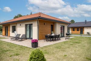 a house with a patio with a table and chairs at Baltijos parkas - Šventoji in Šventoji