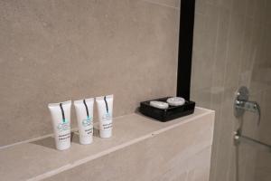 Trendy apartment in Almohamadia في الرياض: ثلاث فرشاة أسنان وصندوق أسود على رف في الحمام