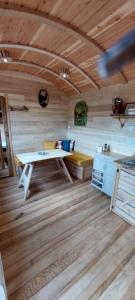 a room with a table in a wooden cabin at Roulotte Le Coq La Mazille in Anglure-sous-Dun