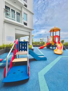 a playground with slides and play equipment in front of a building at 45 Neutral Style Studio for 3 in Iloilo City
