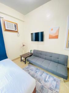 a living room with a blue couch and a table at 45 Neutral Style Studio for 3 in Iloilo City