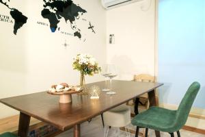 a dining room with a wooden table and green chairs at Fantasy Lodge in Tokyo