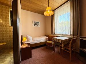 una piccola stanza con un letto e un tavolo di Pension Wollmert a Reinhardshausen