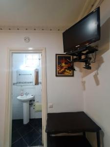 a flat screen tv hanging on the wall of a bathroom at Riad Baddi in Salé +191 photos