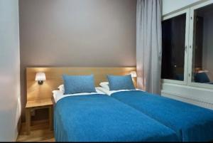 a bedroom with a blue bed and a window at Ruka Ski Chalets, Ski-In Ski-Out in Ruka