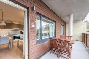 a patio with two benches and a table and a kitchen at Ruka Ski Chalets, Ski-In Ski-Out in Ruka