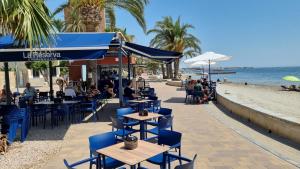 een café op het strand met blauwe stoelen en tafels bij La Casa de V&V - Roldán - Région de Murcie in Las Pedreñas