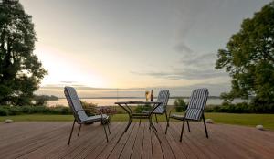 a table and two chairs on a wooden deck at Gästehaus Niederhof in Sundhagen-Niederhof