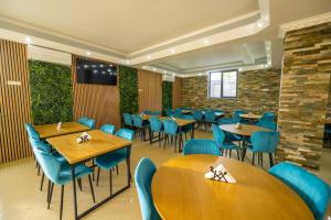 a dining room with tables and blue chairs at Casa Topaz Mamaia Nord in Mamaia Nord