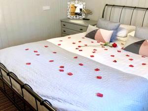 a bedroom with a bed with red roses on it at Beech Lodge 4 Hot Tub in York
