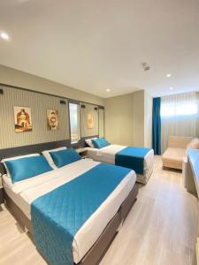 una habitación de hotel con dos camas y un sofá en Sky Luxe Hotel Konyaaltı, en Antalya