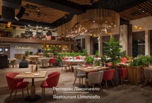 a restaurant with tables and chairs and plants at Apartel Uzhhorod in Uzhhorod