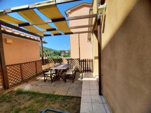 a patio with a table and chairs on a balcony at Pergola n.3 in Cavo