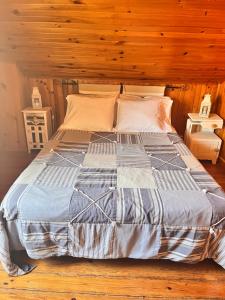 a large bed in a room with wooden walls at Pensão José das Hortas in Costa Nova