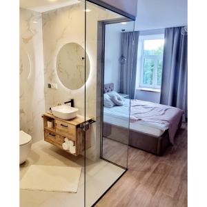 a bathroom with a mirror and a bed and a sink at Dundagas rezidence in Dundaga +29 photos
