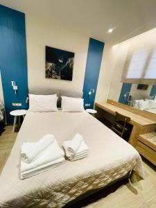 a bedroom with a large bed with towels on it at Modern Apartment, Few Meters from the Beach in Néa Koróni