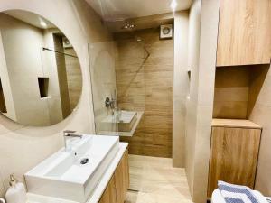 a bathroom with a sink and a mirror at Modern Apartment, Few Meters from the Beach in Néa Koróni +14 photos