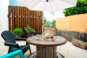 a patio table with an umbrella and two chairs at La Margotte Fibre Terrasse in Voiron