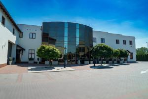 a large glass building with trees in front of it at Hotel Reśliński in Grodzisk Wielkopolski +83 photos