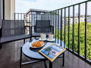 a table with a plate of croissants on a balcony at Luxury in City -14- Stylish Free Parking in Łódź