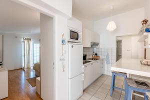 een keuken met witte kasten en een witte koelkast bij Apartment Siranovic in Batalaži