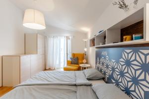 een slaapkamer met een bed met een blauw-witte muur bij Apartment Siranovic in Batalaži