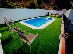 a group of chairs sitting next to a swimming pool at Casa Paula in Almuñécar