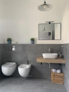 Un baño con dos lavabos, un inodoro y un espejo. en MILANO 71 HOME, en Milán