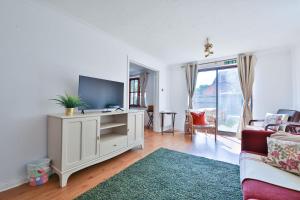 un salon avec une télévision et un canapé dans l'établissement Homely 5 Bed House - 15 Mins to Cardiff City, à Cardiff 29 autres photos