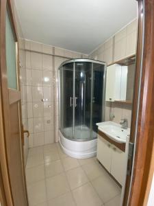un bagno con doccia in vetro e lavandino di Blue 61 Residence a Pelitli