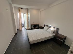 a bedroom with a bed and a table and a chair at Train Station Guesthouse in Faro